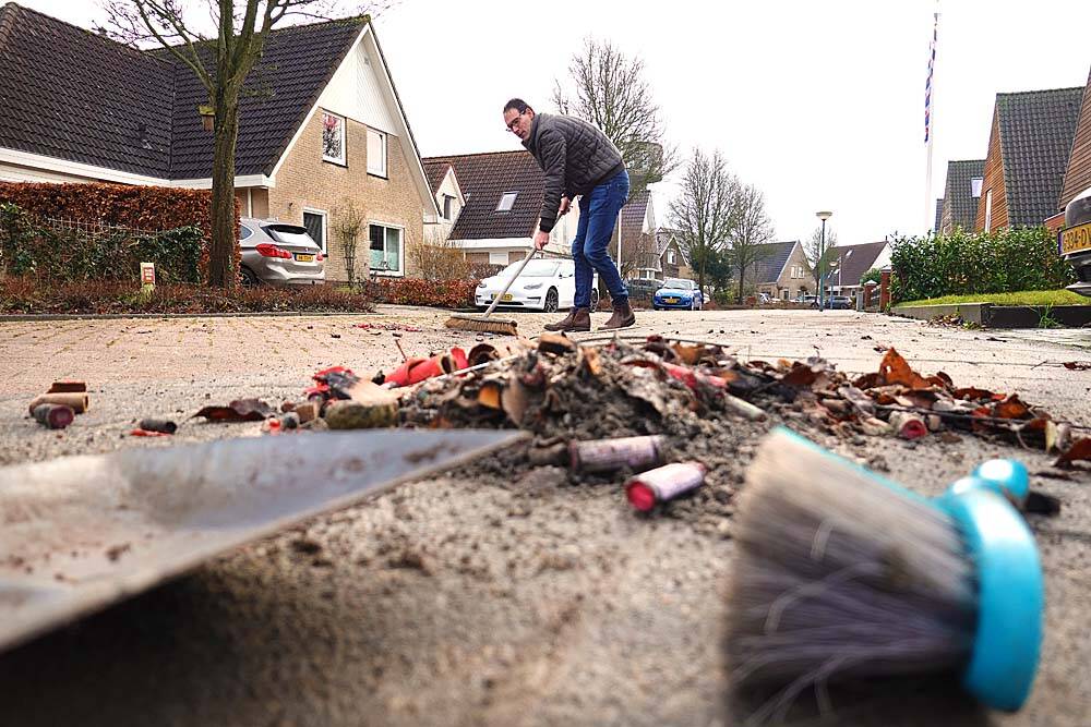In zijn uppie veegt Gerard Groothedde het wegdek van De Reak in Nes schoon