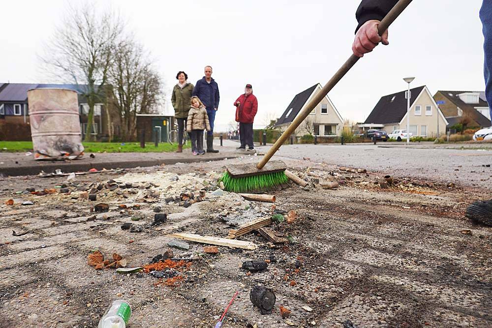  Op de hoek van de Suster van der Vegtstrjitte-Leppedyk: terwijl de feestvierders nog op een oor liggen, veegt een buurman de grootste troep aan.