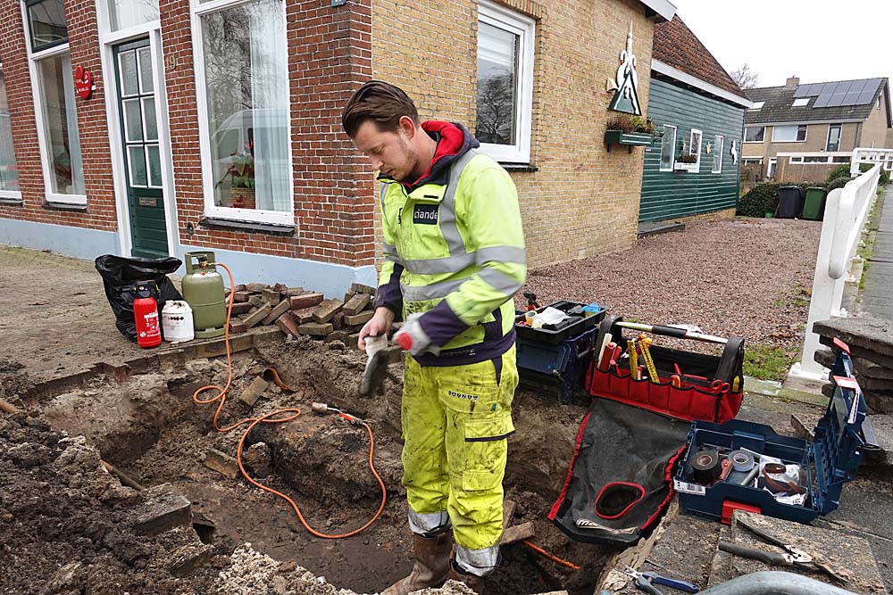 Een medewerker van netwerkbeheerder splitst een stroomkabel. Netwerkbeheerder Liander is druk bezig met de verzwaring van het stroomnet.