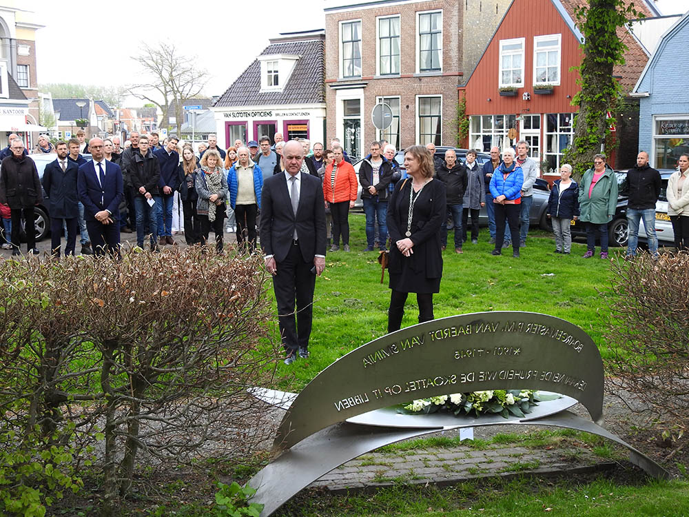 De Friese commissaris van de Koning Arno Brok (links vooraan) legt samen met wethouder Gerrie Rozema een krans.
