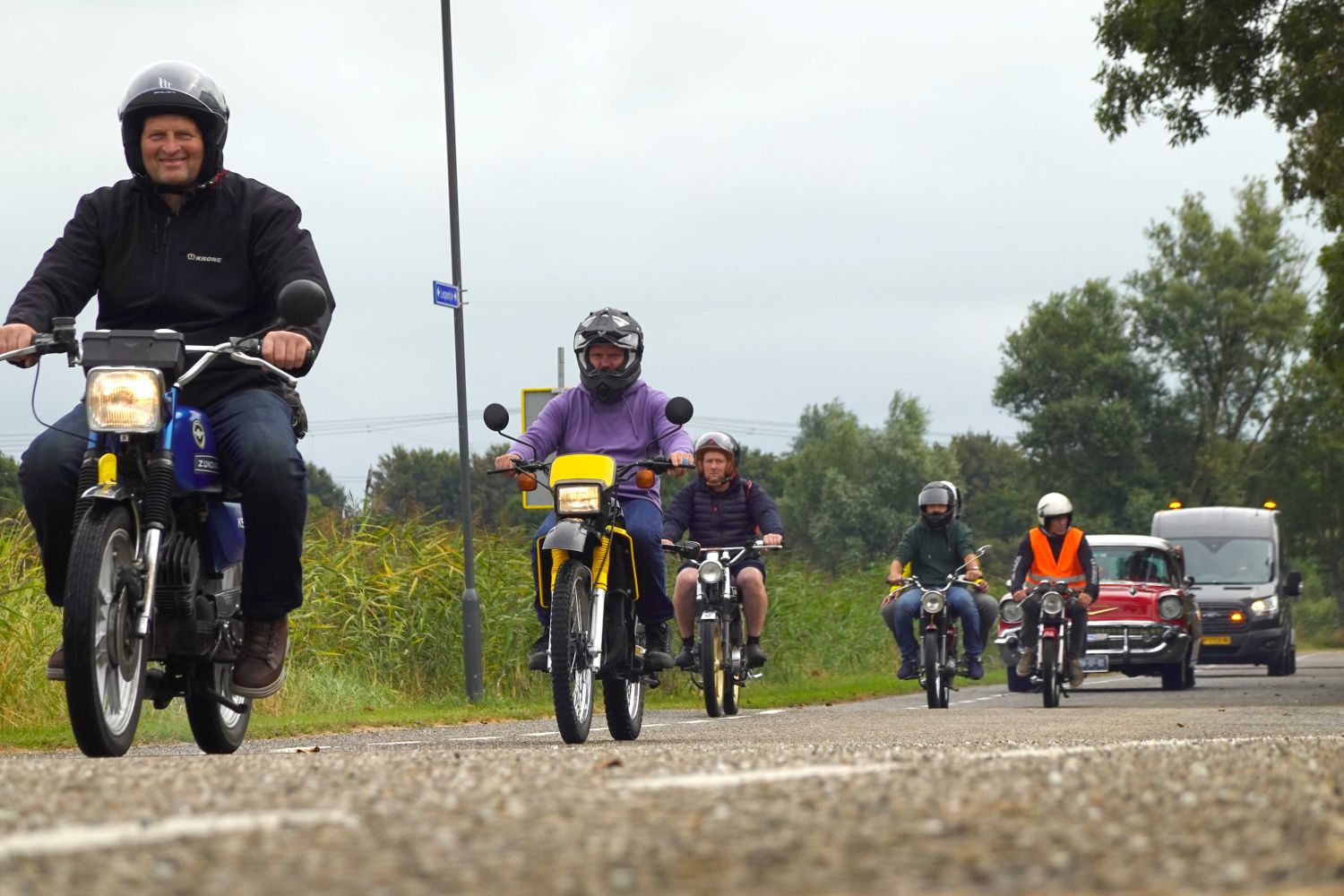 Historische brommers en legervoertuigen trekken over Leppedyk