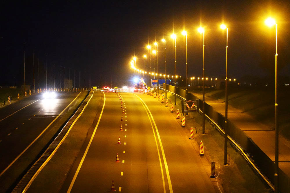 Een lange rij lichtmasten tussen Heerenveen en Grou verlichten de nachtelijke werkzaamheden aan de rijksweg A32, die over een traject van tien kilometer volledig wordt gesloopt en opnieuw gebouwd.