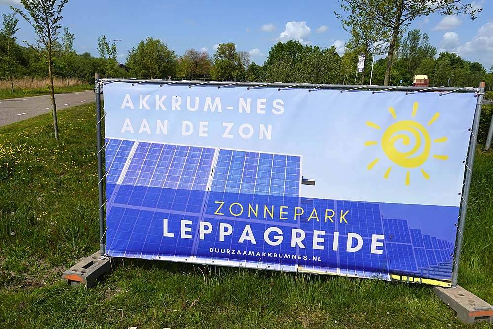 Reclamedoeken voor het zonnepark Leppagreide zijn zaterdag op verschillende plaatsen in Akkrum en omgeving geplaatst. Voorzitter Tom Yntema en de bestuursleden Piet Dijkstra en Zwier Kroese reden zaterdagochtend hun rondje langs belangrijke verkeerspunten, zoals hier pas voor de Brede School. De doeken worden opgehangen in de aanloop naar de opening van het zonneparkt tijdens Reuzedei 2022 op zaterdag 28 mei 2022.