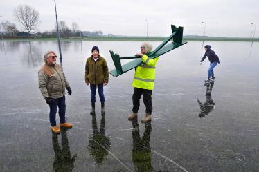 Zoeven over gitzwarte ijsvloer in Akkrum