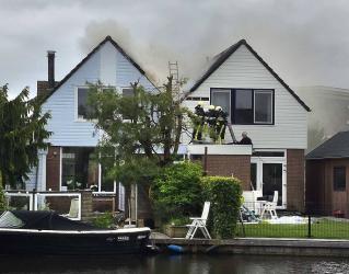 Geschakelde woningen Akkrum in brand; rook over woonwijk