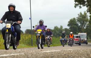 Historische brommers en legervoertuigen trekken over Leppedyk